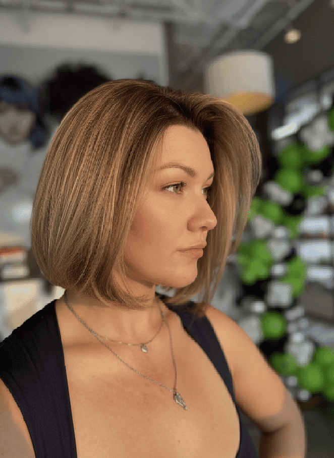 Profile of a woman with short hair in a stylish indoor setting.
